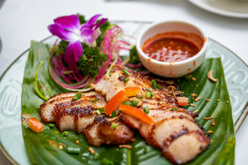 A plate of crispy and delicious roasted pork neck with Thai chutney