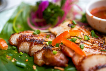 A plate of crispy and delicious roasted pork neck with Thai chutney