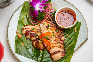 A plate of crispy and delicious roasted pork neck with Thai chutney