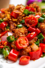 A plate of spicy and crispy fried chicken with crispy double peppers