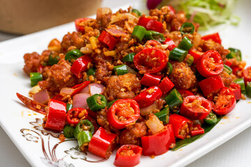 A plate of spicy and crispy fried chicken with crispy double peppers