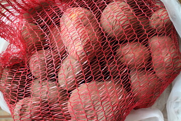 red mesh with unwashed potatoes