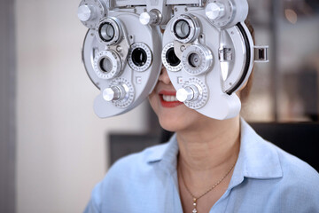 Asian middle age woman doing an eye exam in optical shop, modern diagnostic ophthalmology equipment, selective focus