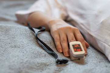 Measurement of saturation in a patient with covid. Saturator on the finger to measure the level of oxygen in the body. © Andrii