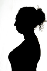 silhouette of young brunette woman in profile backlight