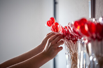 Red heart-shaped lollipops on the counter of a candy store.