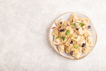 Dumplings with pepper, herbs, microgreen on gray concrete. Top view, flat lay, copy space.