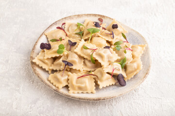 Dumplings with pepper, herbs, microgreen on gray concrete. Side view.
