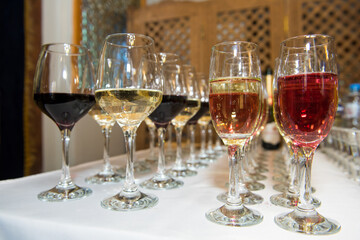 Glasses of wine on the festive table. A party with alcohol for guests.