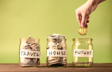 Dollars in three glass money jar. Saving for travel, house and bitcoin coin for the future