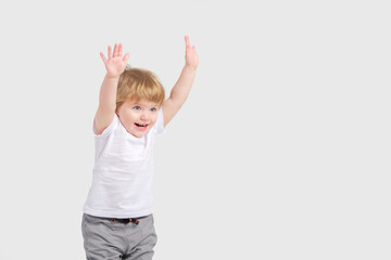 A happy child holds his hands up and laughs. White background. Copy space . 