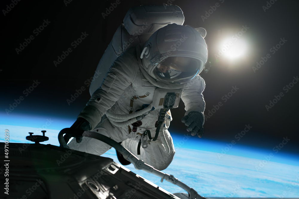 Canvas Prints female astronaut performing spacewalk, working on a outer part of a space craft