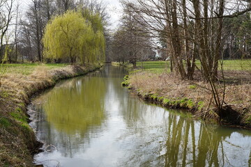 Fototapeta na wymiar Ein Wasserlauf im Spreewald fliesst durch die Stadt Burg