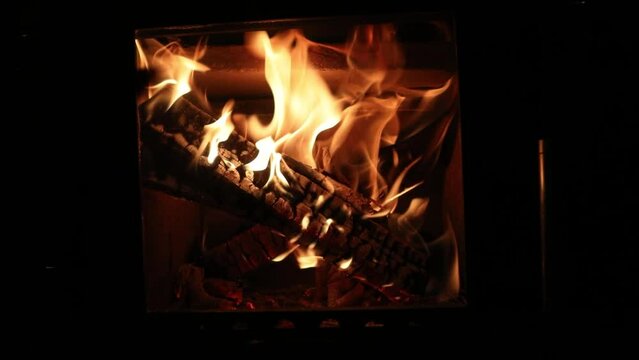 Footage of a bright colored dancing flames in fireplace. Close up of burning firewood. Cozy warm background