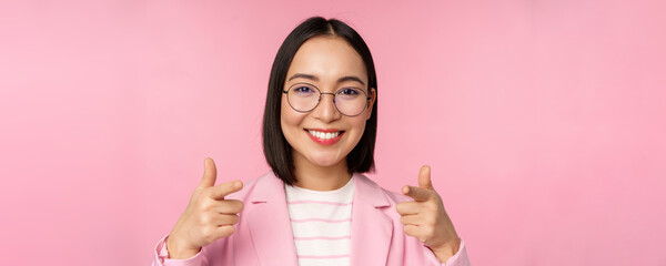 Its you, congratulations. Smiling asian corporate woman, ceo manager in suit and glasses, pointing...