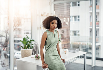 My door is always open. Cropped portrait of an attractive young businesswoman leaning against her...