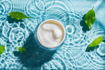 beauty cream and green leaves on clear water