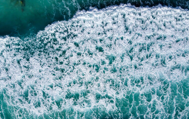 Drone aerial view ocean waves. Blue water background. Aerial view to seething waves with foam. 
