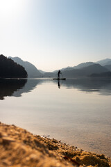 Stand up paddle board on an austrian lake with beautiful reflection and Mountains