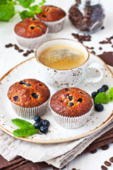Blueberry muffins with fresh berries and coffee mug