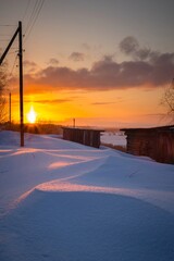 Winter rural sunset with reflection of light in drifts of snow. winter scenery