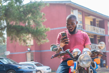 african bike man checks phone and looks surprised