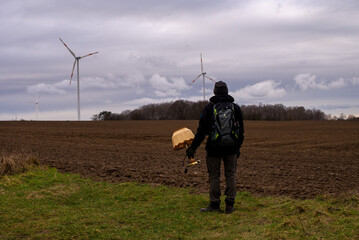 a man with the lamp on the field with wind turbine