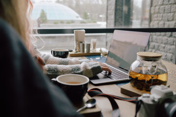 two happy young women sitting in coffee shop looking at laptop computer. side view