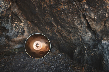 Musical instrument handpan leaning against a rocky wall. It is also known as a hang or pantam.