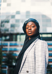 Confident black woman in traditional headscarf and formal wear