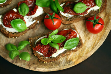Selective focus. Macro. Healthy toast with sun-dried tomatoes and basil. Italian food. Mediterranean snack.