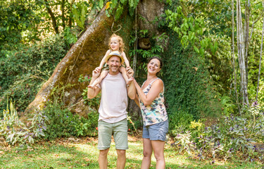 Fototapeta premium family and a small 2 year old daughter in the summer in tropical palm trees and flowers.