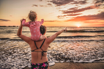 happy family at the beach a mother child daughter having fun at sunset