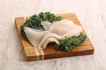 Raw squid over wooden board