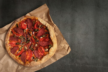 pepperoni pizza and basil tomato ingredients on a black concrete background. Top view of hot pepperoni pizza. With space to copy text