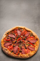pepperoni pizza and basil tomato ingredients on a black concrete background. Top view of hot pepperoni pizza. With space to copy text
