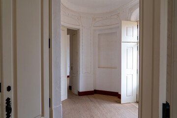 elegant empty round room with wooden floors and tall white walls and large French Doors