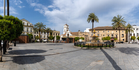 Fototapeta na wymiar panorama view of the Plaza de Espana Square in the city center of Merida with its fountain and palm trees