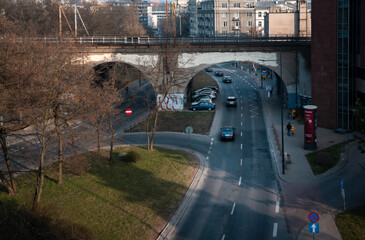 Cars drive under the railway bridge.