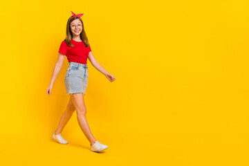 Fototapeta na wymiar Full size photo of pretty cheerful laughing girl go on walk step move travel summer vacation isolated on yellow color background