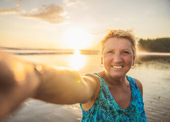 senior woman having good time on sunset beach