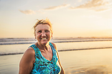 senior woman having good time on sunset beach