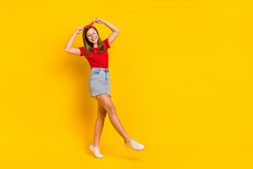 Fototapeta na wymiar Full size photo of funky carefree retro girl go walk dancing fix adjust headband isolated on yellow color background