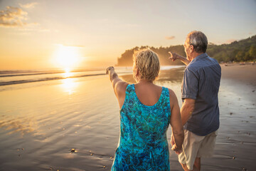 Fototapeta premium Senior Couple Enjoying Beautiful Sunset on the Beach