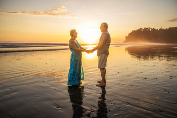 Fototapeta premium Senior Couple Enjoying Beautiful Sunset on the Beach