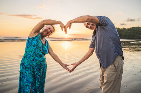 Senior Couple Enjoying Beautiful Sunset on the Beach - Powered by Adobe