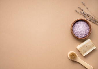 Plakat Flat lay organic sea salt for the body with dry lavender flowers, brush and soap on a beige background. Skin care. The concept of a natural and eco-friendly spa product. Top view, copy space