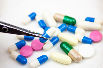 Pick up the tablets with tweezers. Examination of medicines. Research pills and drugs laboratory...