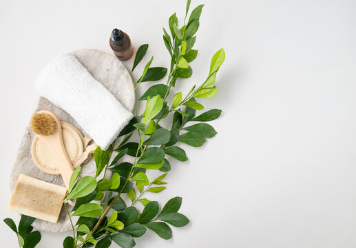 Flat Lay Of Facial And Body Care Cosmetics With Soap, Brush, Sponge, Creme And Towel  On White  Background With Brunch. Zero Waste Concept. Top View And Copy Space