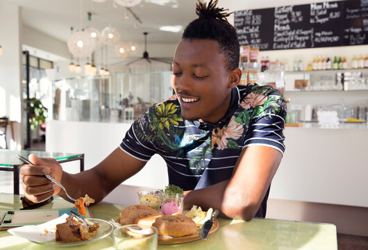 Smiling man enjoying breakfast in cafe
